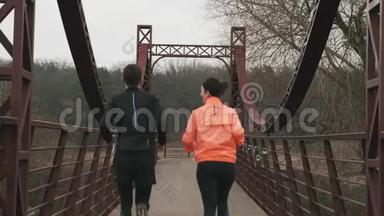 在帕克兰，一对年轻的运<strong>动</strong>夫妇在桥上奔跑。 穿着鲜艳运<strong>动</strong>装慢跑的<strong>男女</strong>运<strong>动</strong>员
